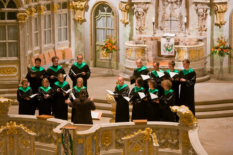 Chorsänger und Dirigentin während eines Konzerts in der Frauenkirche Dresden