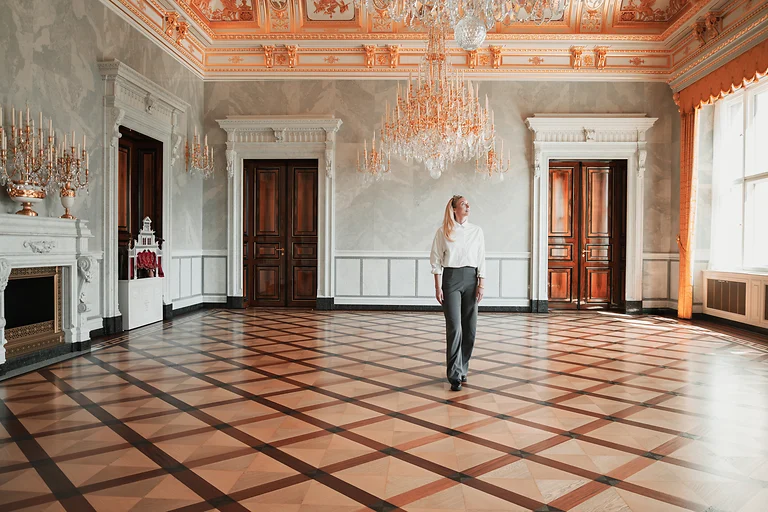 Frau im Kleinen Ballsaal des Residenzschlosses Dresden vor barocker Architektur und Kristallleuchtern.