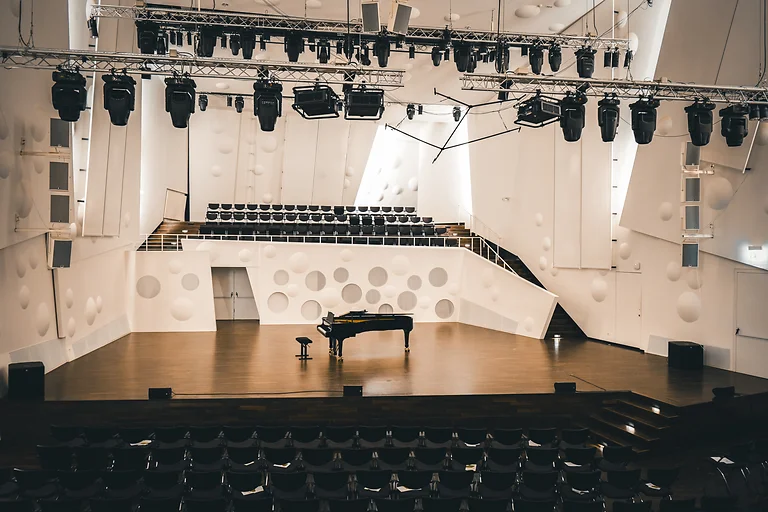 Blick auf Bühne und Empore im Konzertsaal der Hochschule für Musik Dresden mit klarer Architektur.
