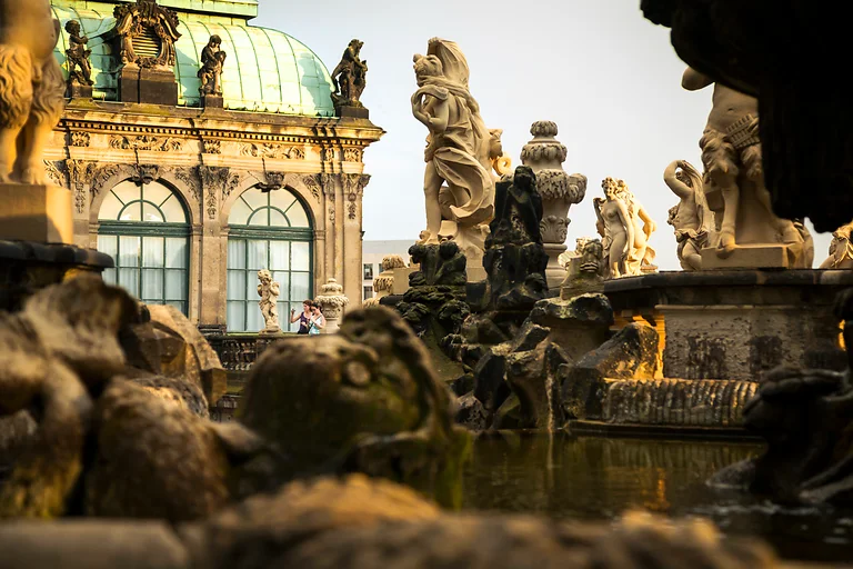 Skulpturen im Nymphenbad des Dresdner Zwingers auf Balustraden mit Blick auf barocke Architektur.