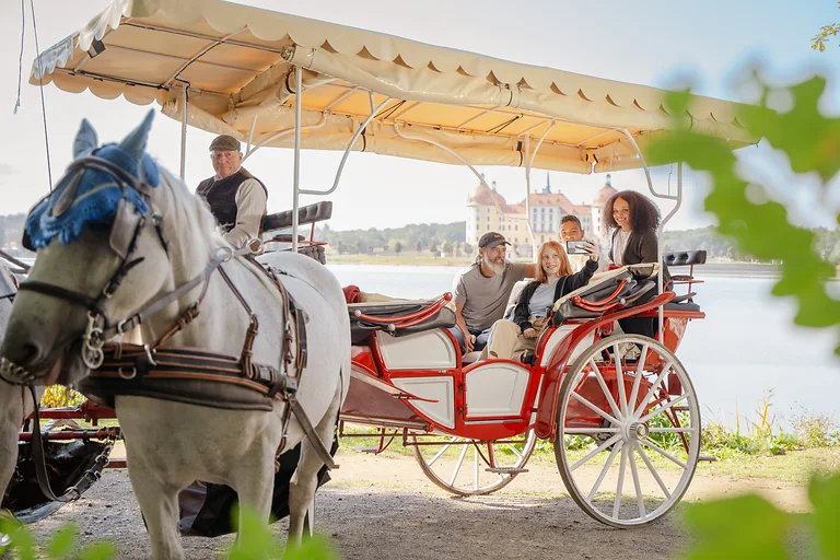 Family takes a carriage ride with a view of Moritzburg Castle in the Dresden Elbland.
