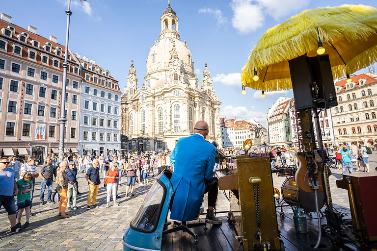Musiker spielt auf den Dresdner Kulturinseln vor der Frauenkirche, Besucher genießen das Sommerprogramm.