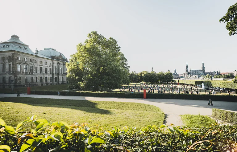 Menschen praktizieren Yoga vor dem Japanischen Palais im Rahmen des Palais Sommer.