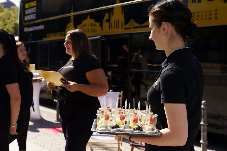Empfang bei der Roadshow „Dresden Convention on Tour 2024“ mit Obst und Cake Pops, im Hintergrund der GourmetLiner.