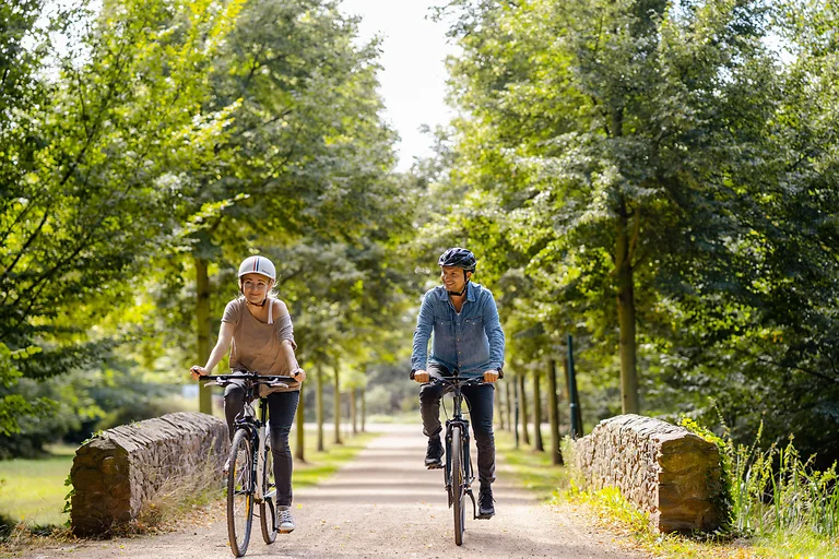 Cyclists relax on a bike route in the Dresden Elbland, surrounded by green scenery.