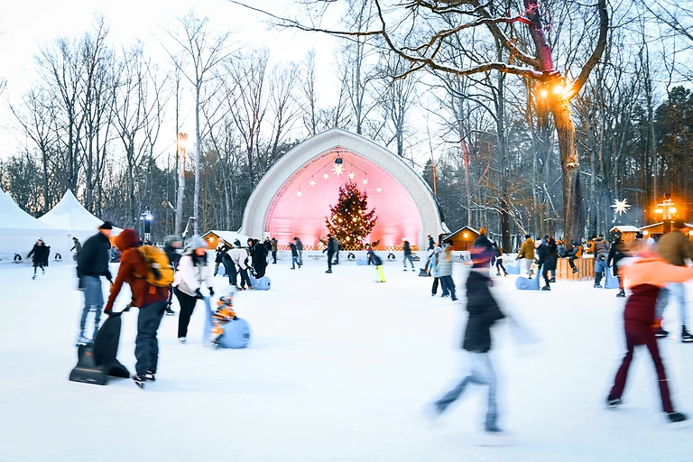 Eisläufer bewegen sich über die Eisfläche am Konzertplatz Weißer Hirsch in Dresden.