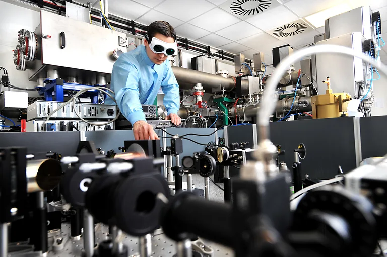 Forscher am Helmholtz-Zentrum Dresden-Rossendorf experimentiert mit der Terahertz-Quelle im ELBE-Zentrum und trägt dabei eine spezielle Schutzbrille.