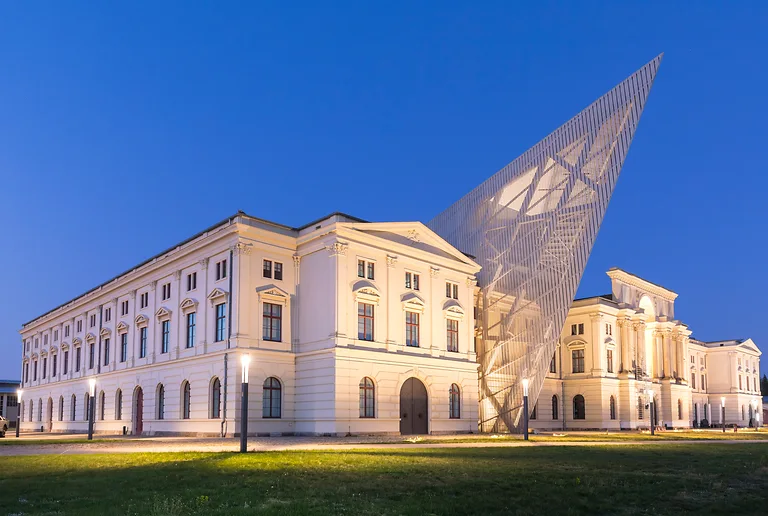 Military History Museum Dresden at night with illuminated Libeskind building and striking architecture.