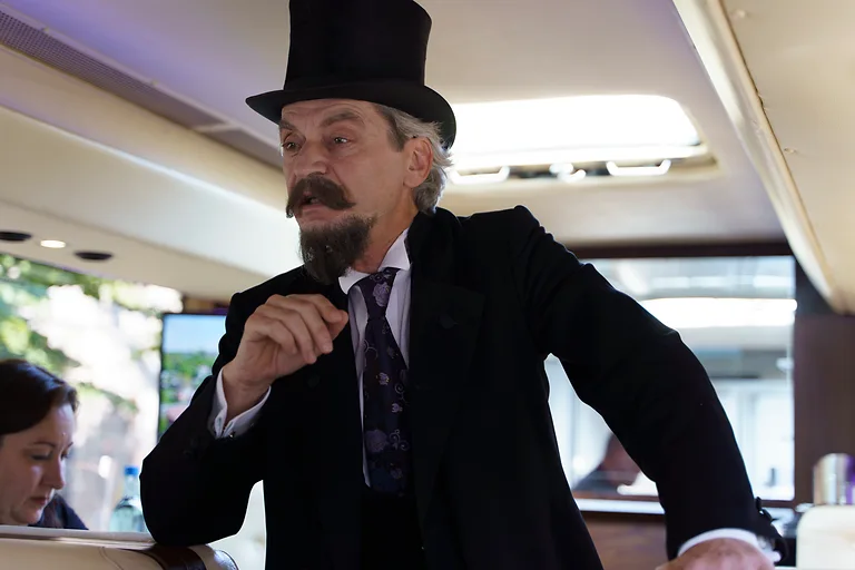 Ein als Karl August Lingner verkleideter Schauspieler steht im GourmetLiner-Bus und führt Gäste durch Dresdens Erfindungsgeschichte.