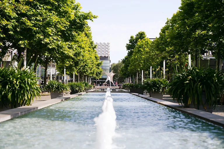 Prager Straße in Dresden mit Brunnen, Sitzgelegenheiten und Geschäften als lebendiger Treffpunkt in Dresden.