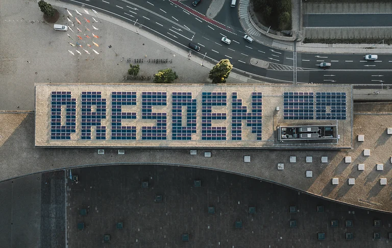 Auf dem Dach des Kongresszentrums ist eine Photovoltaikanlage in Form des Schriftzugs „DRESDEN“ zu sehen.