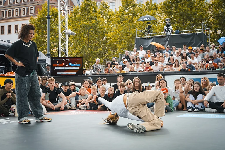Breakdance Battle bei den Finals 2025 in Dresden, Tänzerin performt vor großem Publikum auf dem Wettkampfplatz.