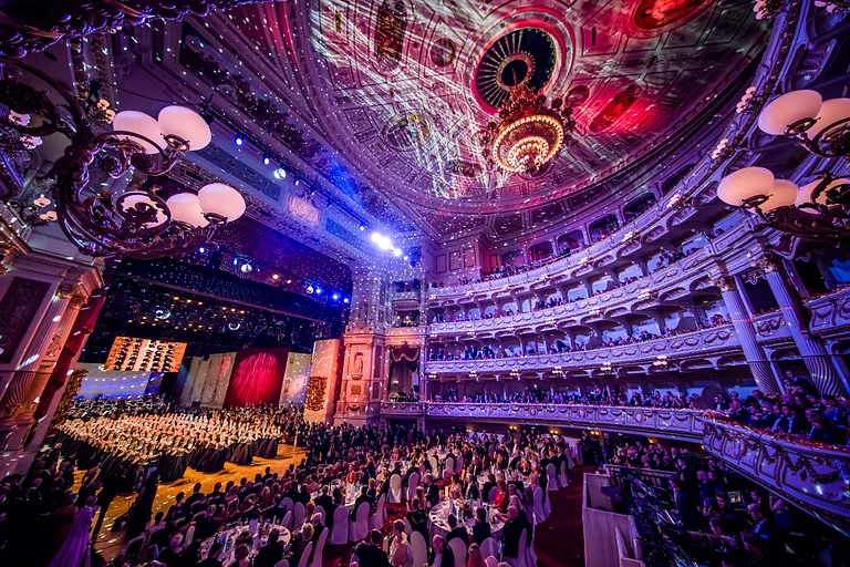 Der SemperOpernball in Dresden mit elegant gekleideten Gästen im festlich erleuchteten Opernhaus.