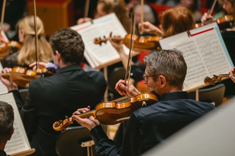 Streicher der Dresdner Philharmonie im Konzert im Kulturpalast Dresden, Nahaufnahme im Spielmoment.