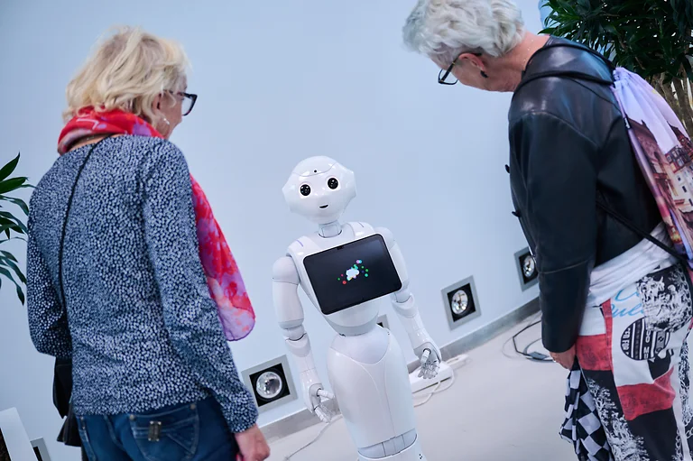 Zwei Frauen betrachten einen Roboter in der Gläsernen Manufaktur Dresden